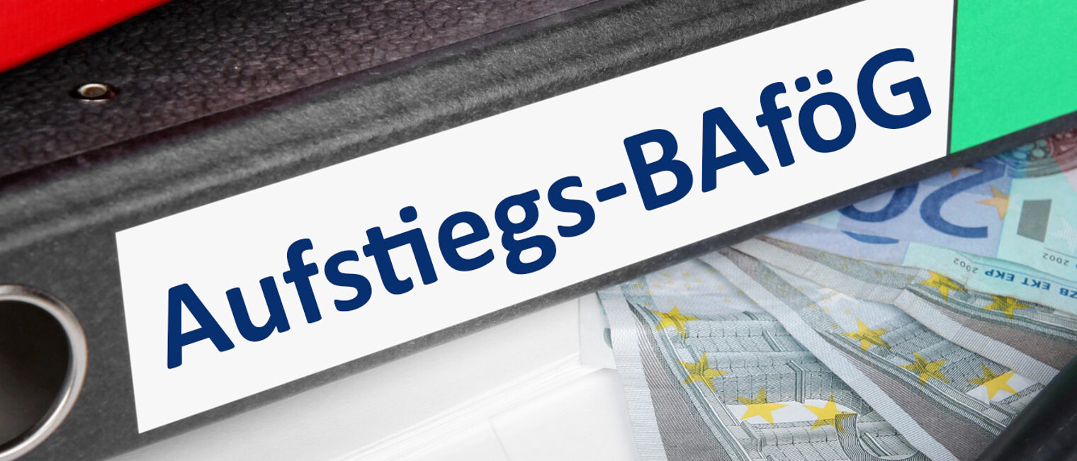 Büroordner mit der Aufschrift Aufstiegs- BAföG auf 20 Euro Scheinen liegend