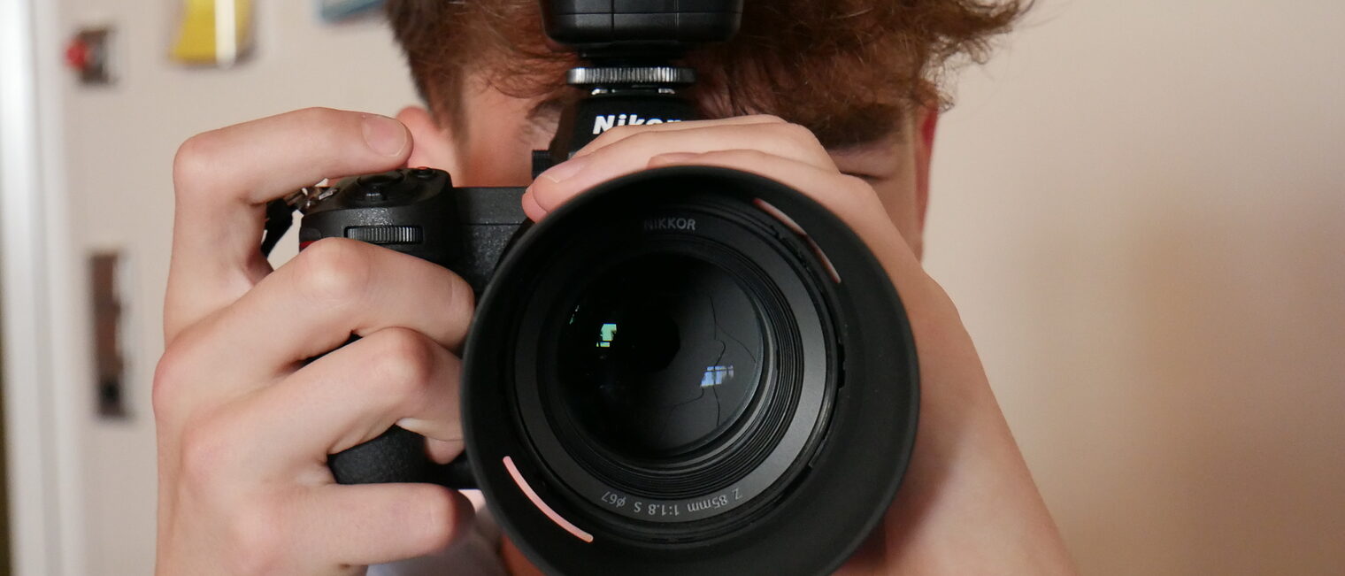 Ein Junge schaut durch einen Fotoapparat.