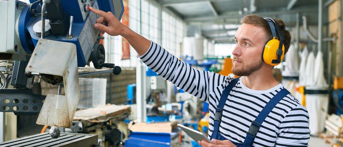 Weiterbildung von der Agentur für Arbeit fördern lassen Azubi bedient Maschine
