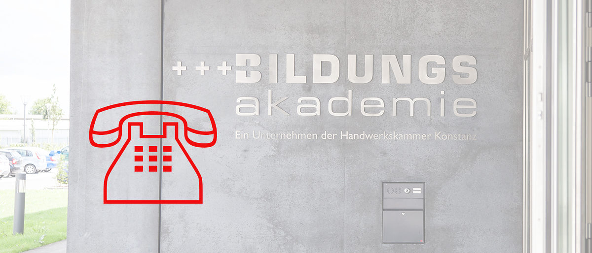 Die Bildungsakademien sind geschlossen, die Beratung geht weiter. Rotes Telefonsymbol vor Gebäude der Bildungsakademie Singen