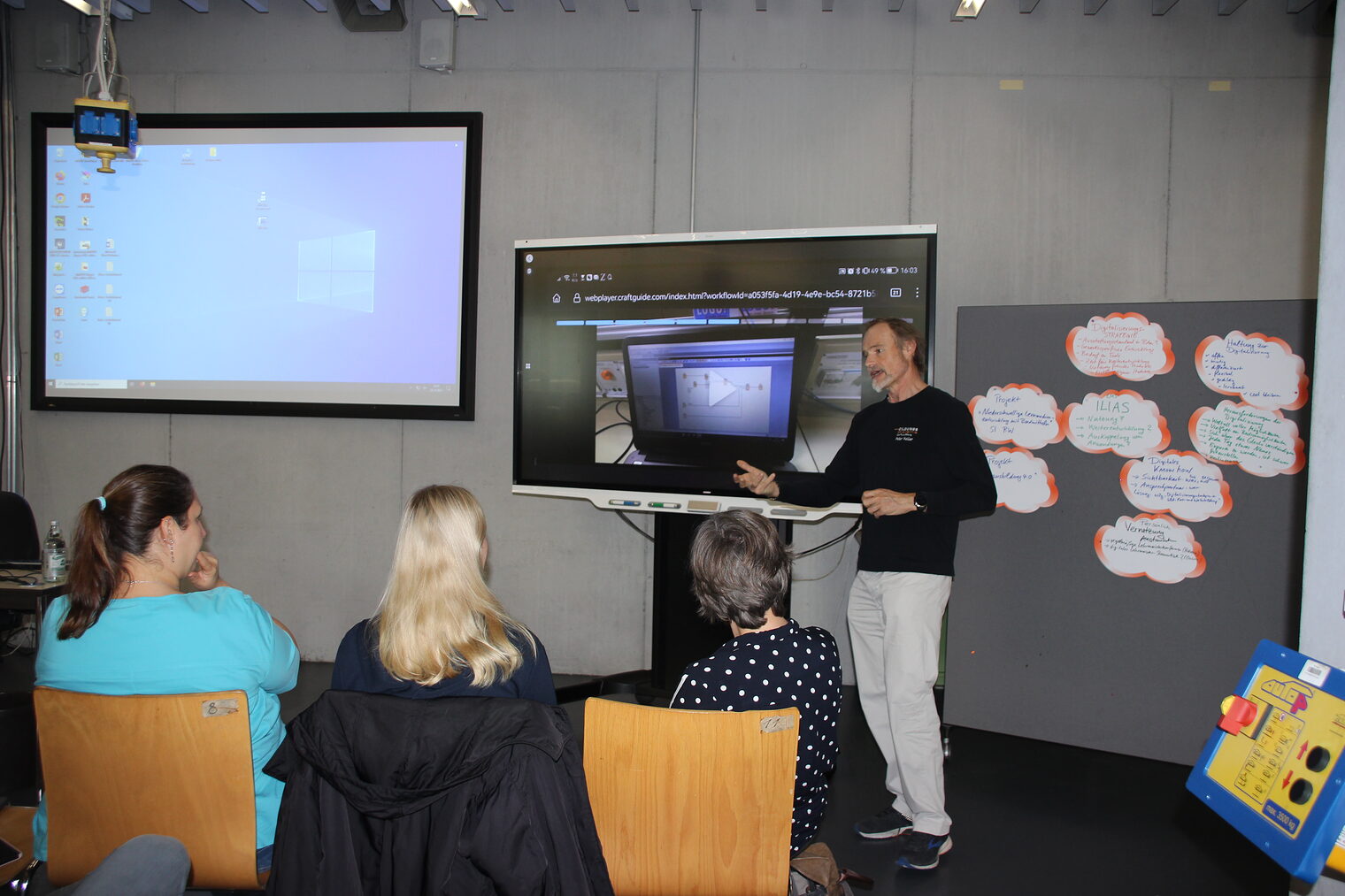 Peter Keller, Dozent in der Bildungsakademie Waldshut steht vor einer Leinwand mit einer Präsentation zur Erstellung von Lehrvideos. Davor sitzen die Teilnehmer des Workshops. 