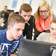 Vier Auszubildende die an einem Kurs teilnehmen schauen auf ein Computerdisplay 