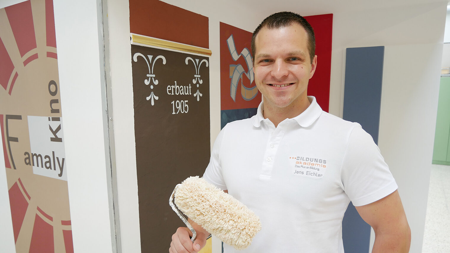 Portrait von Jens Eichler mit Malerrolle in der Hand.