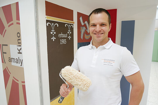 Portrait von Jens Eichler mit Malerrolle in der Hand.
