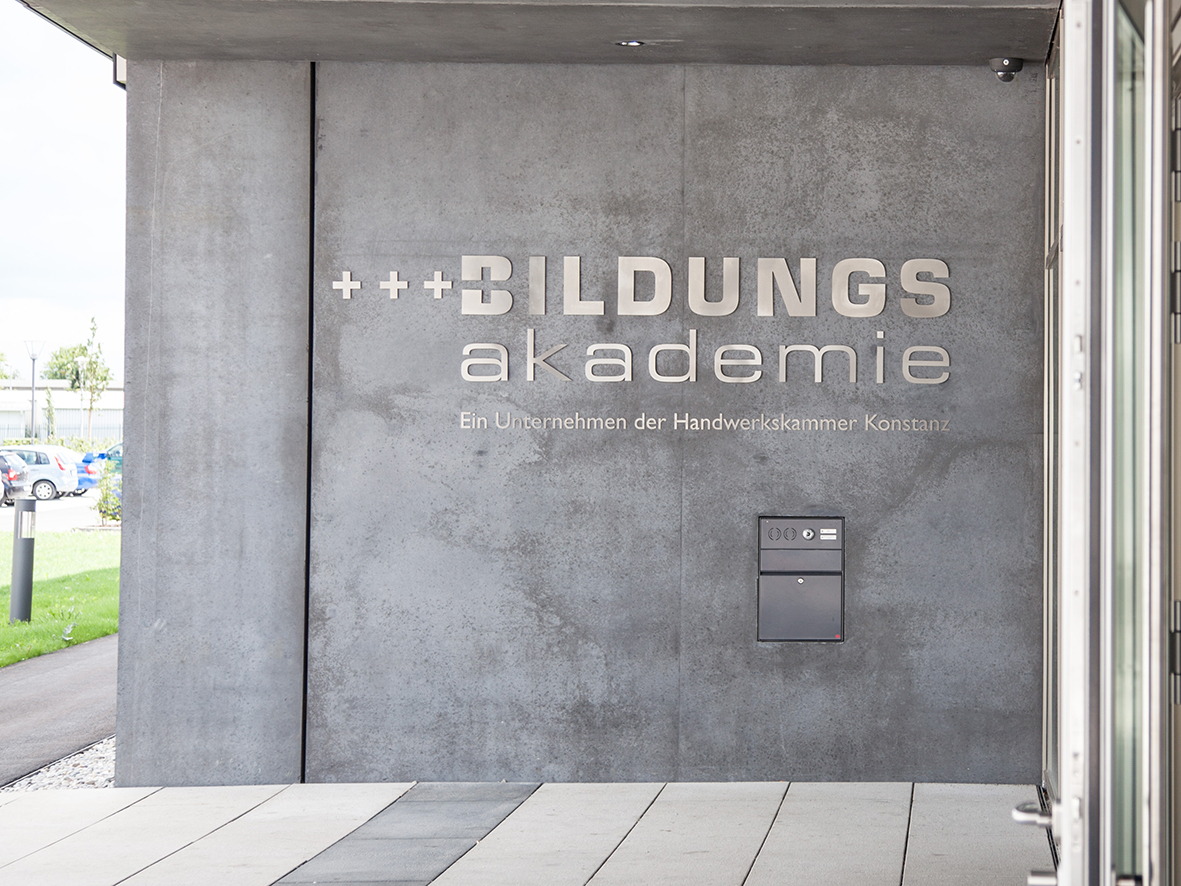 Schriftzug Bildungsakademie - Ein Unternehmen der Handwerkskammer Konstanz an der Fassade am Eingangsbereich der Bildungsakademie Singen.