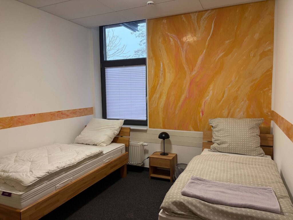 Azubi-Wohnheim in Waldshut: Zweibettzimmer mit gelber Wand.